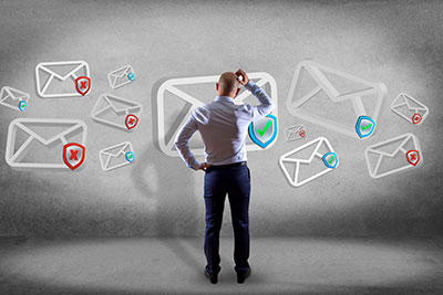 man standing scratching head looking at array of mail icons some marked with red Xs