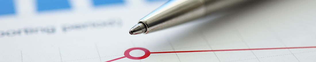 close up of ballpoint pen tip laying alongside red graph with single data point