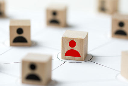 wooden blocks with human shaped heads on front one of which is red, the others black