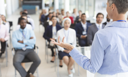 instructor at head of classroom with audience